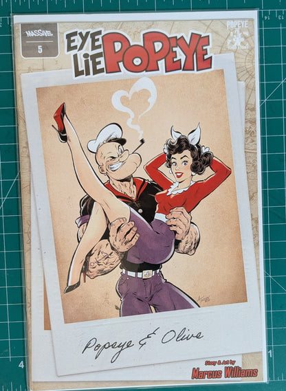 A comic book or art print featuring Popeye and Olive from Eye, Lie, and Popeye, displayed on a green cutting mat. The cover shows Popeye carrying Olive in a classic retro illustration style with the title 'Eye Lie Popeye' at the top.